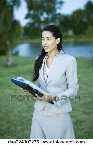 Businesswoman walking through park with laptop View Large Photo Image Stock Photograph - Businesswoman walking through park with laptop. Fotosearch