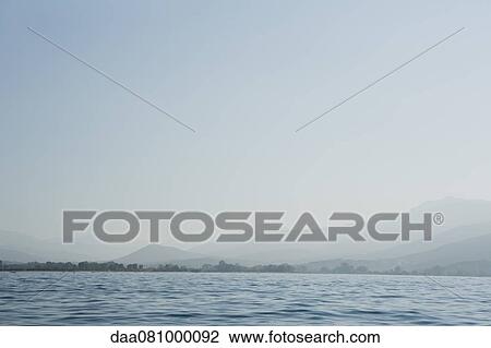 Calm sea with horizon over land in distance View Large Photo Image Stock Image - Calm sea with horizon over land in distance. Fotosearch