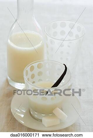 Stock Image - Carafe and glass of eggnog, with vanilla pod and sugar cubes. Fotosearch