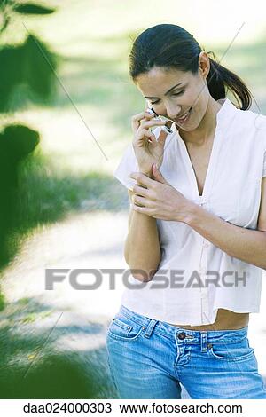 Casually dressed woman using cell phone, smiling View Large Photo Image Stock Image - Casually dressed woman using cell phone, smiling. Fotosearch