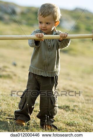 Child holding on to wooden stick View Large Photo Image Stock Photograph - Child holding on to wooden stick. Fotosearch