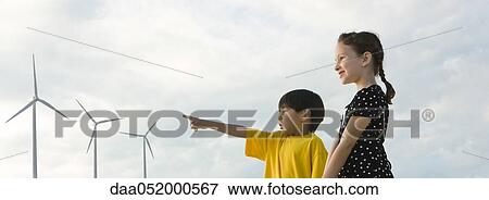 Stock Photo - Children looking at wind turbines. Fotosearch