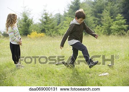 Stock Image - Children playing in field. Fotosearch