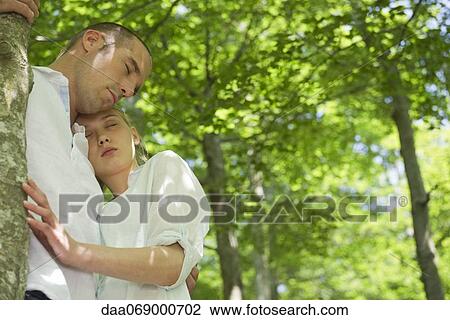 Couple embracing in woods with eyes closed View Large Photo Image Stock Image - Couple embracing in woods with eyes closed. Fotosearch
