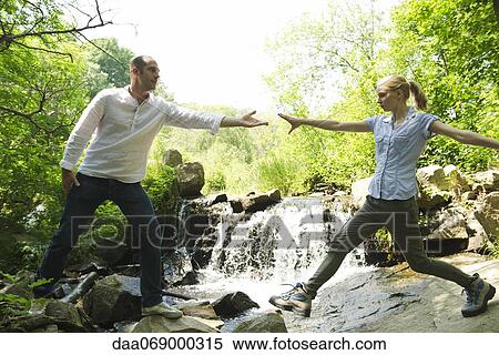 Couple hiking, woman reaching for man's hand View Large Photo Image Stock Photography - Couple hiking, woman reaching for man's hand. Fotosearch