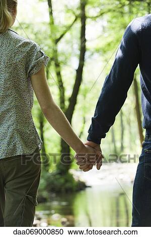 Couple holding hands in woods, cropped View Large Photo Image Stock Image - Couple holding hands in woods, cropped. Fotosearch