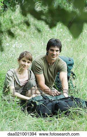 Picture - Couple of hikers in grass. Fotosearch