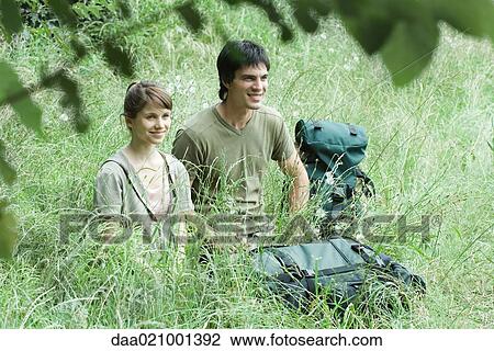 Couple of hikers in grass View Large Photo Image Stock Image - Couple of hikers in grass. Fotosearch