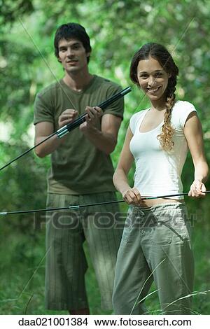 Picture - Couple putting up tent in wilderness. Fotosearch