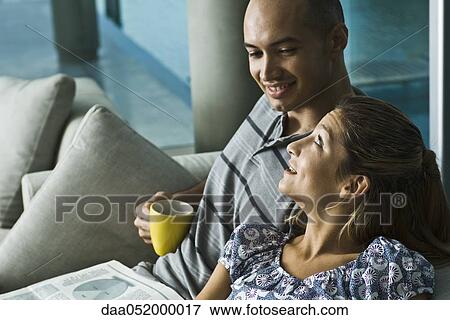 Couple relaxing together at home View Large Photo Image Stock Photo - Couple relaxing together at home. Fotosearch