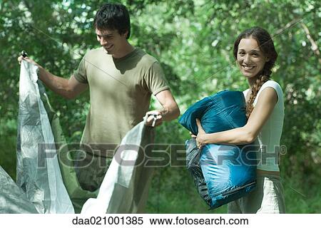 Stock Photography - Couple setting up campsite in wilderness area. Fotosearch