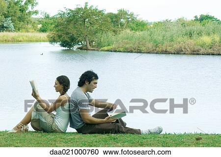 Couple sitting by lake, back to back, reading View Large Photo Image Stock Image - Couple sitting by lake, back to back, reading. Fotosearch