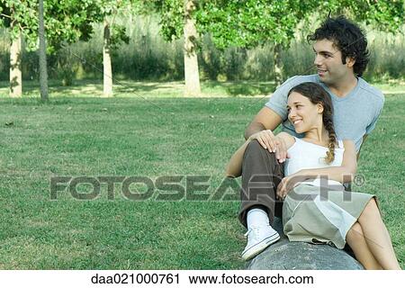Couple sitting on log, woman leaning against man, both looking away View Large Photo Image Stock Image - Couple sitting on log, woman leaning against man, both looking away. Fotosearch