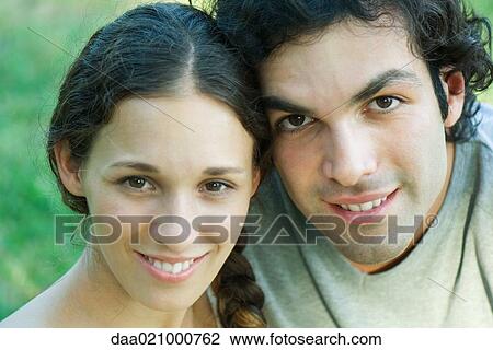 Stock Image - Couple smiling at camera, portrait, close-up, head and shoulders. Fotosearch