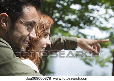 Couple together outdoors, looking at view View Large Photo Image Stock Photo - Couple together outdoors, looking at view. Fotosearch
