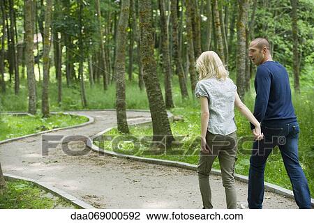Couple walking on path in woods View Large Photo Image Stock Image - Couple walking on path in woods. Fotosearch