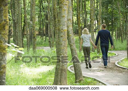 Stock Photo - Couple walking on path in woods. Fotosearch