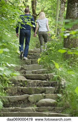 Couple walking up stone steps in woods View Large Photo Image Stock Photo - Couple walking up stone steps in woods. Fotosearch