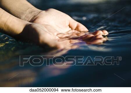Cupped hands catching water View Large Photo Image Picture - Cupped hands catching water. Fotosearch