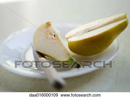 Cut pear on plate with knife View Large Photo Image Stock Photo - Cut pear on plate with knife. Fotosearch