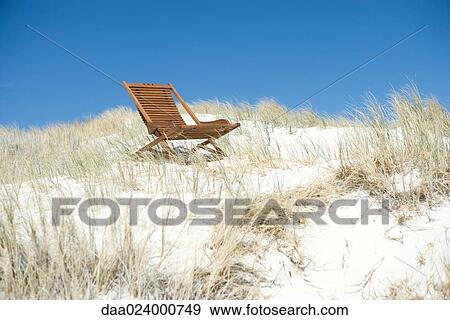 Deck chair in dunes View Large Photo Image Stock Photo - Deck chair in dunes. Fotosearch