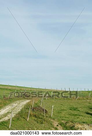 Stock Image - Dirt road through rural landscape. Fotosearch