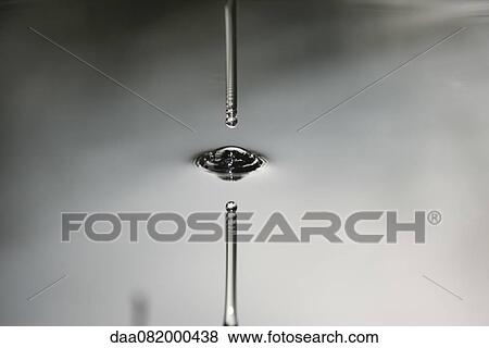 Stock Photo - Drop hitting smooth surface of water. Fotosearch