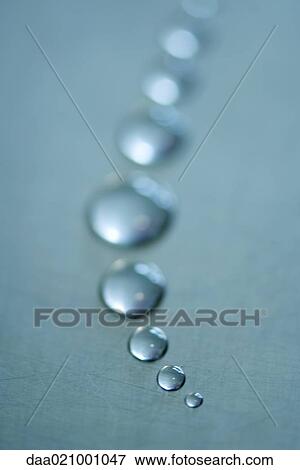 Stock Photo - Drops of water arranged in curve, close-up. Fotosearch