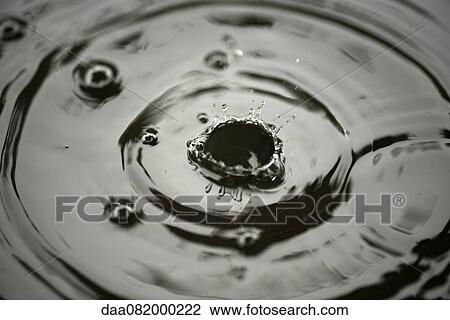 Stock Image - Drops splashing on water. Fotosearch