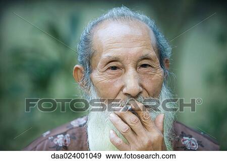 Elderly man smoking cigarette View Large Photo Image Stock Photo - Elderly man smoking cigarette. Fotosearch
