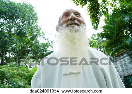 Picture - Elderly man wearing traditional Chinese clothing, smiling, low angle view. Fotosearch