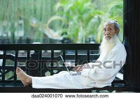 Elderly man wearing traditional Chinese clothing, using laptop, full length View Large Photo Image Stock Image - Elderly man wearing traditional Chinese clothing, using laptop, full length. Fotosearch