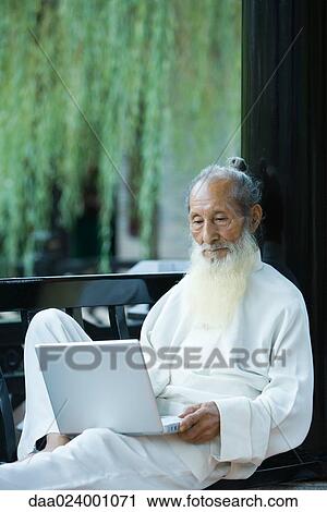 Elderly man wearing traditional Chinese clothing, using laptop View Large Photo Image Stock Image - Elderly man wearing traditional Chinese clothing, using laptop. Fotosearch