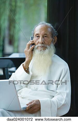 Elderly man wearing traditional Chinese clothing, using laptop and cell phone View Large Photo Image Stock Image - Elderly man wearing traditional Chinese clothing, using laptop and cell phone. Fotosearch
