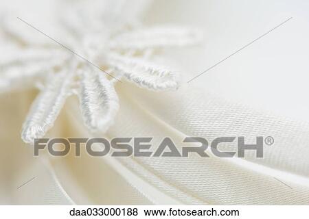 Stock Photo - Embroidered flower on fabric, extreme close-up. Fotosearch