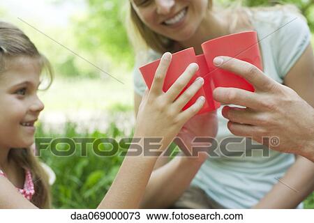 Stock Image - Family clinking glasses at outdoor picnic, cropped. Fotosearch