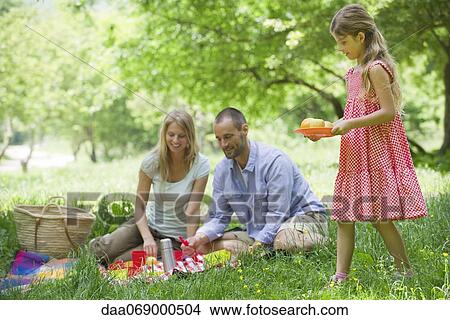 Family enjoying picnic outdoors View Large Photo Image Picture - Family enjoying picnic outdoors. Fotosearch