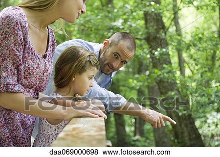 Family outdoors together, looking over railing View Large Photo Image Stock Photo - Family outdoors together, looking over railing. Fotosearch