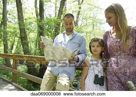 Stock Photo - Family pausing in woods to consult map. Fotosearch