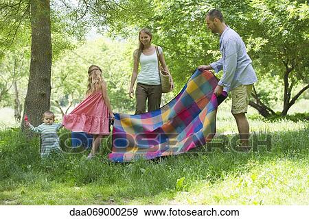 Family preparing for picnic in meadow View Large Photo Image Stock Photo - Family preparing for picnic in meadow. Fotosearch