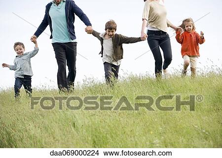 Family running together in field View Large Photo Image Picture - Family running together in field. Fotosearch