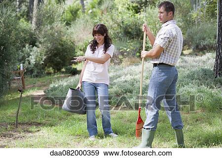 Stock Photo - Father and daughter working together in garden. Fotosearch