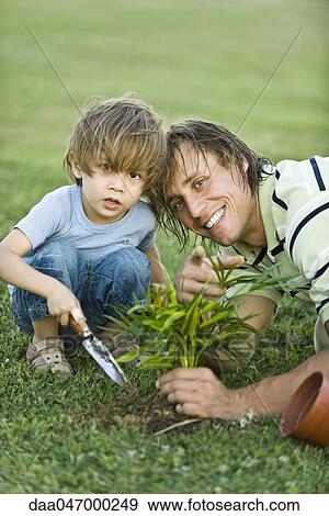 Father and son planting seedling View Large Photo Image Stock Photo - Father and son planting seedling. Fotosearch