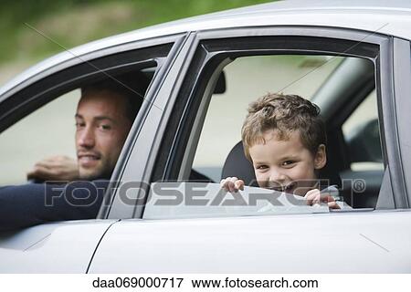 Stock Photo - Father and son smiling out car window at camera. Fotosearch