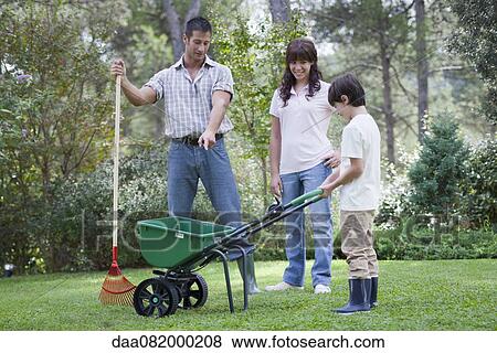 Stock Photo - Father and two children working together in yard. Fotosearch