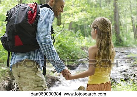 Father and young daughter hiking together in woods View Large Photo Image Picture - Father and young daughter hiking together in woods. Fotosearch