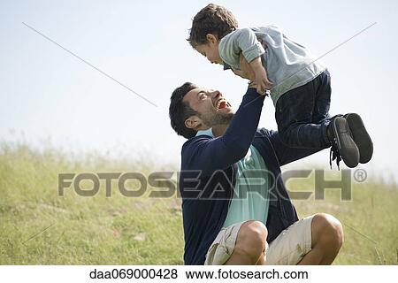 Stock Photo - Father and young son playing outdoors. Fotosearch