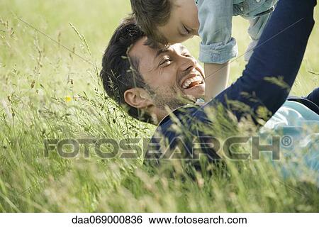 Father and young son playing together outdoors, cropped View Large Photo Image Stock Photograph - Father and young son playing together outdoors, cropped. Fotosearch