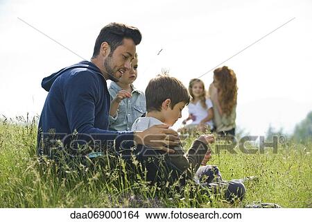 Picture - Father talking with young sons outdoors. Fotosearch