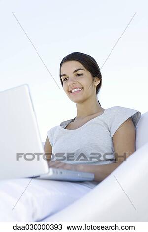 Female using laptop computer, smiling, low angle view View Large Photo Image Stock Image - Female using laptop computer, smiling, low angle view. Fotosearch